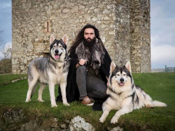 William Mulhall in front of Audley's Castle, in Co Down, with Thor (left) and Odin, two Northern Inuit dogs he owns which played 'direwolves' in the hit HBO fantasy drama, Game Of Thrones