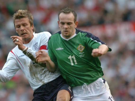 Former Glentoran player Stuart Elliott does battle with David Beckham