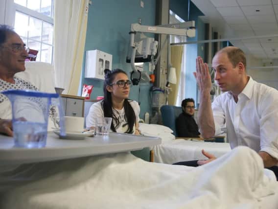 The Duke of Cambridge speaks to patient Vusof Omar (left) during his visit to the Royal Marsden NHS Foundation Trust in London, to see the Trust's facilities and view pioneering robotic surgeries