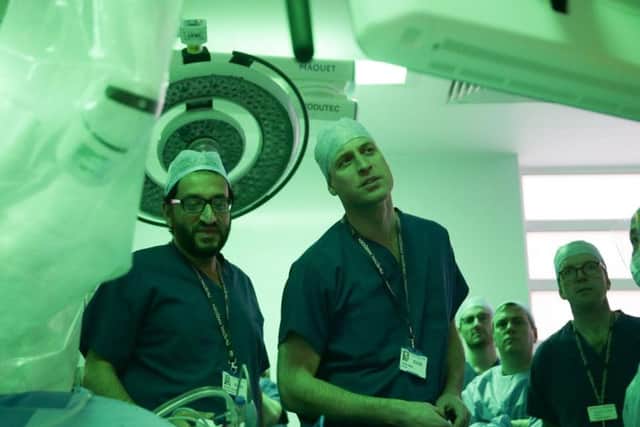 The Duke of Cambridge and lead surgeon Asif Chaudry (left) stand in front of a da Vinci XI machine prior to a highly complex robotic cancer operation to remove a tumour of the oesophagus at the junction between the heart, lungs and aorta of patient Charles Ludlow, 63, during his visit to the Royal Marsden NHS Foundation Trust in London