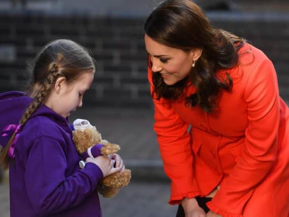 The Duchess of Cambridge is given teddies by a girl as she arrives to officially open the Mittal Children's Medical Centre during a visit to Great Ormond Street Hospital