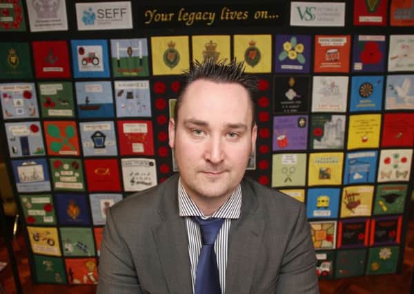 Kenny Donaldson, director of services at Innocent Victims united, in front of a quilt made by family members from Fermanagh who lost loved ones in Troubles terrorism. 
Picture Colm O'Reilly Press Eye 2015