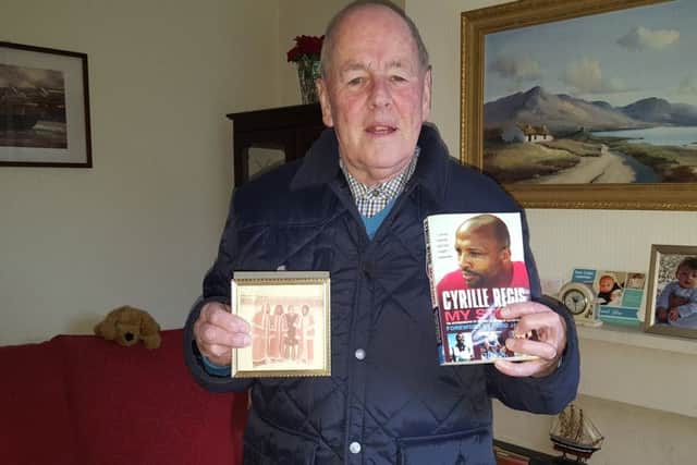 Gordon Hamilton with a photo of himself with Cyrille Regis Laurie Cunningham and Brendon Batson (three former West Bromwich Albion players) and a signed copy of Cyrille Regis'  book