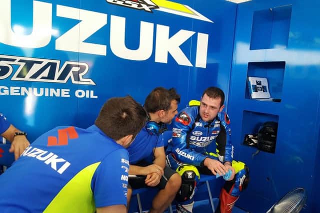 Ballymoney's Michael Dunlop in a debrief with the Ecstar Suzuki team following his MotoGP debut at Sepang on Thursday.