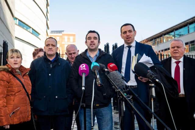 Aaron McCone (son of John Harbinson, 2nd left), Joe Convie (father of Gary Convie, 3rd left behind), look on as Keiran Fox (son of Eamon Fox, centre) speaks to the media with solicitor Padraig O'Muirigh (2nd right) and SDLP MLA John Dallas (right) outside Laganside Court