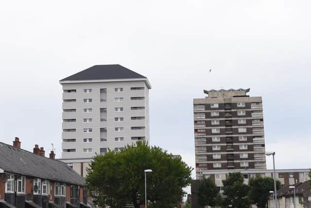 One of the newly-refurbished and clad New Lodge tower blocks next to an old-style one