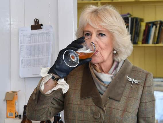 The Duchess of Cornwall tastes an Arkell's Bee's Organic Ale as she is given a tour of Arkell's Brewery in Stratton, Swindon during a visit to mark their 175th anniversary year.