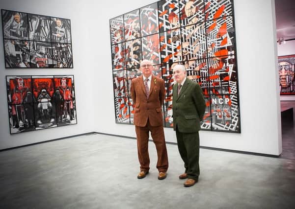 Gilbert & George in front of some of their pictures at the MAC, Belfast
