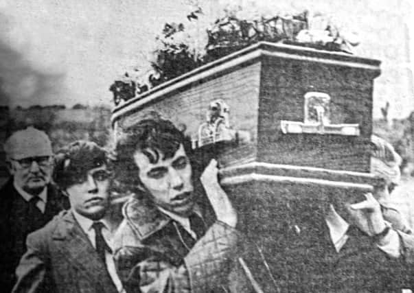 Alan Freeburn carries the coffin of his father Robert into Kingsmills Presbyterian Church for his funeral after he was killed by the IRA at Kingsmills in 1976.