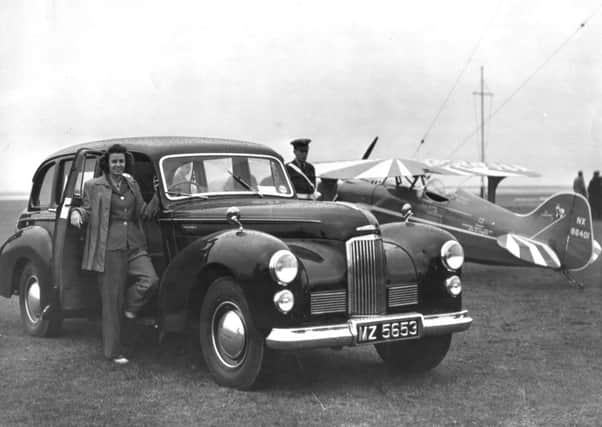 Air ace Betty Skelton, with her stunt plane behind, posing with a Wilton's Humber Car, in Belfast in 1949.
