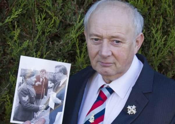 As John Eaglesham remembers the murder of his father 40 years ago, he fears the return of bloodshed across Northern Ireland. Here he holds a photograph of his father in uniform.
