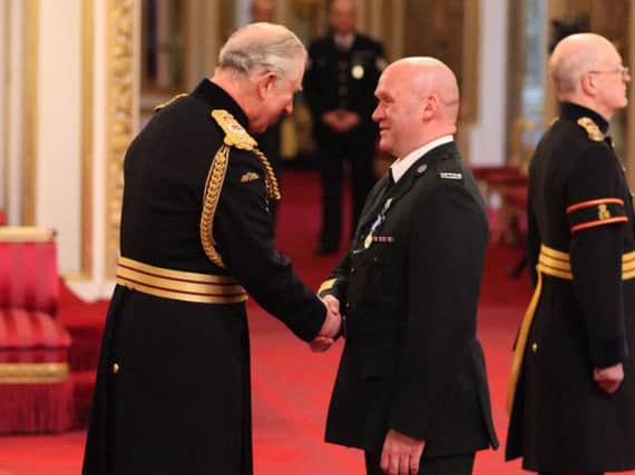 Sergeant Mark Wright, Police Service of Northern Ireland, is decorated with the Queen's Gallantry Medal by the Prince of Wales during an investiture ceremony at Buckingham Palace, London