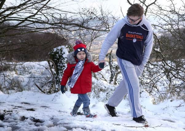 Garry Duffy with his nephew Ruairi O' Reilly enjoying the snow at Cave Hill on Sunday