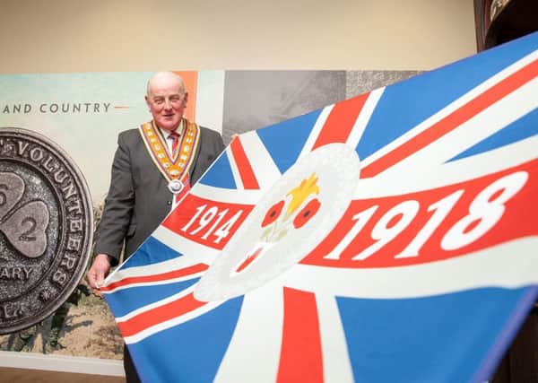 Grand Master Edward Stevenson shows off the commemorative flag paying tribute to Orangemen and women who served during the First World War