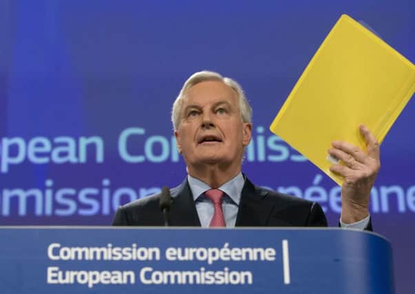 EU chief Brexit negotiator Michel Barnier holds the draft document as he addresses the media in Brussels