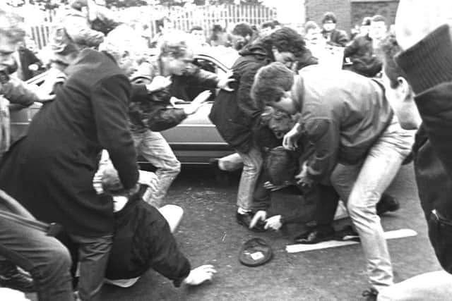 Corporal Derek Woods emerges from his car with his gun in hand and is quickly beaten to the ground by the mob at the IRA funeral of Kevin Brady in March 1988