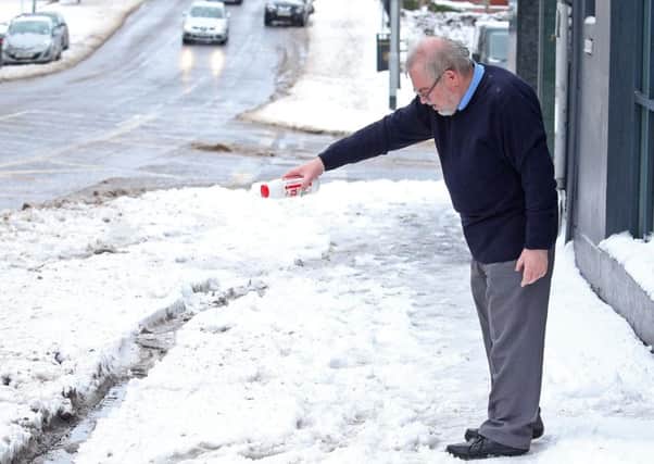Pass the salt: a man tries to keep the snow at bay in Banbridge, Co Down, on Friday