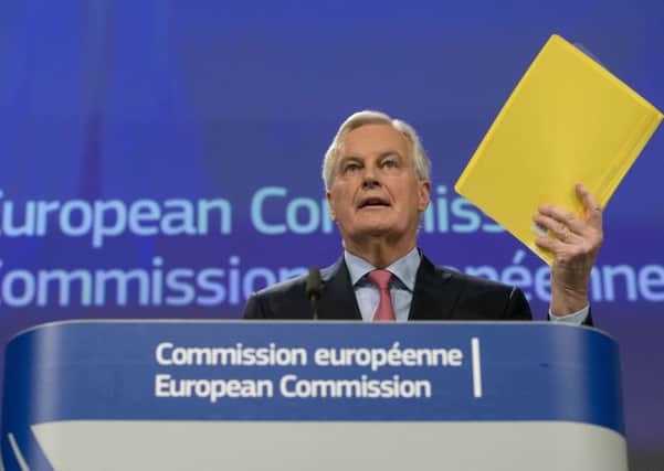 European Union chief Brexit negotiator Michel Barnier holds the draft document which included controversial proposals for Northern Ireland at EU headquarters in Brussels on Wednesday, Feb. 28, 2018. Mr Reees-Mogg says: "The European Commission, under its lead Brexit negotiator Michel Barnier, proposed that a friendly European state should be dismembered at its behest." (AP Photo/Virginia Mayo)