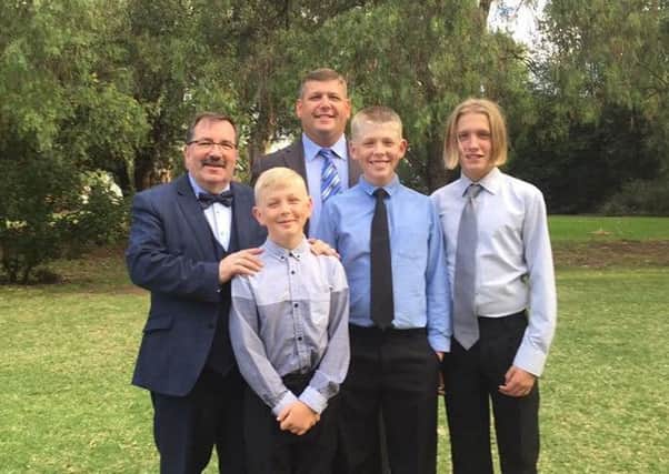 Caleb (dark tie), pictured with Jackson, JJ, his dad and grandfather.