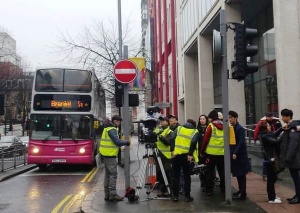 A Chinese film crew filming in Belfast for the film 'Special Couple', at the back of City Hall. The man to the right of the camera with the baseball cap on is producer Jianxin Huang