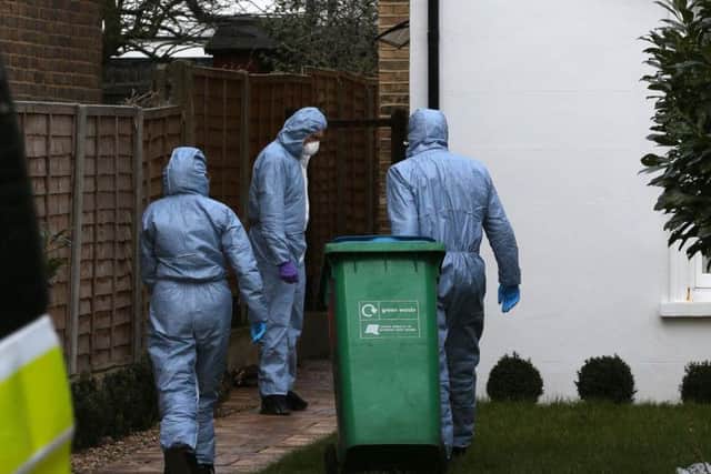 Forensic officers enter a house in South Road, Twickenham, south west London, where a murder investigation has been launched after a woman was found dead with stab wounds at the house and her husband and two young boys found dead at Birling Gap, near Eastbourne, East Sussex.