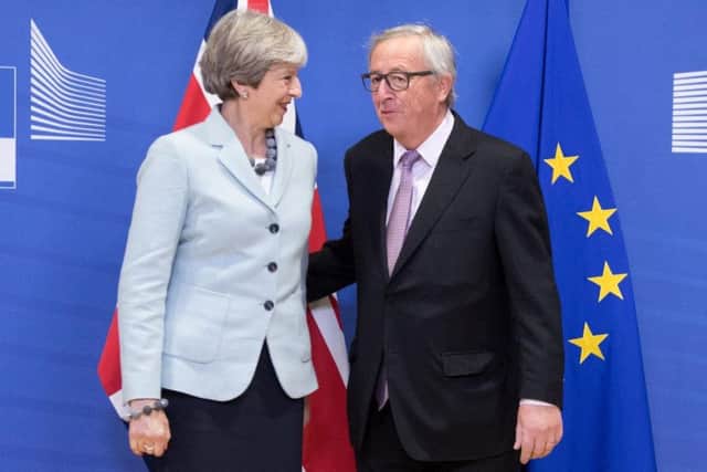 EU President Jean-Claude Juncker standing with British Prime Minister Theresa May at the EU Commission in Brussels.