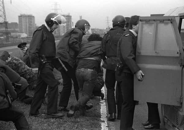 RUC officers arrest loyalist Michael Stone after his gun and grenade attack on Milltown cemetery in March 1988