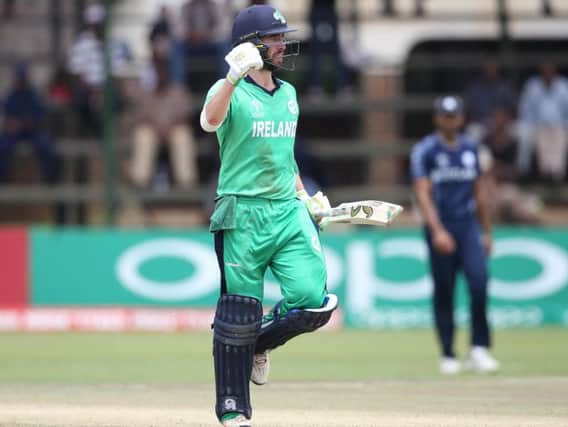 Ireland's Andrew Balbirnie punches the air as he reaches his century against Scotland