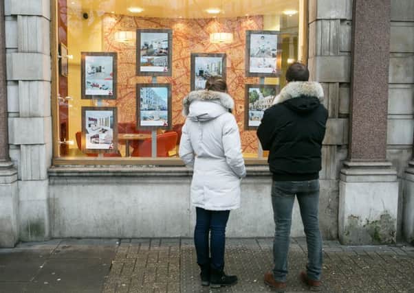 A couple looking in the window of an estate agents, as nearly half of 18 to 35 year-olds are banking on a partner to help them get onto the property ladder, according to research