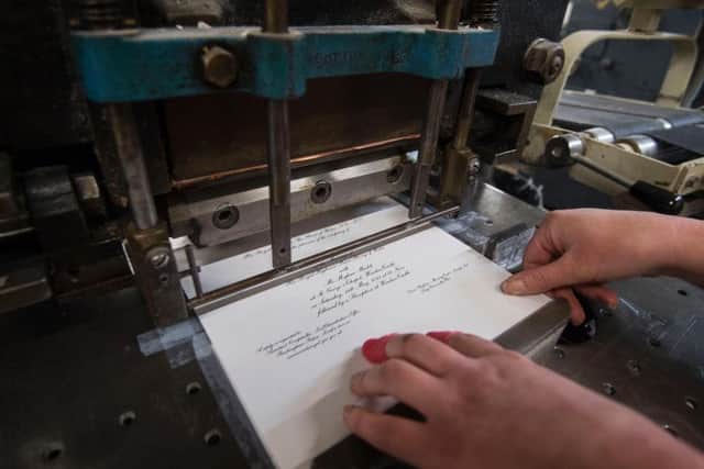 Lottie Small use the die stamping press at the workshop of Barnard and Westwood in London, who are printing the invitations for Prince Harry and Meghan Markle's wedding in May.
