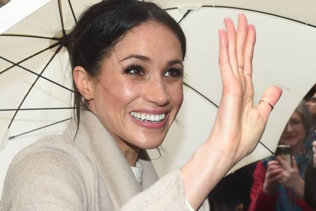 Meghan Markle shelters from the rain under an umbrella as she waves to wellwishers during a walkabout in Belfast after a visit to the Crown Bar in the city centre. PRESS ASSOCIATION Photo. Picture date: Friday March 23, 2018. See PA story ROYAL Harry. Photo credit should read: Joe Giddens/PA Wire