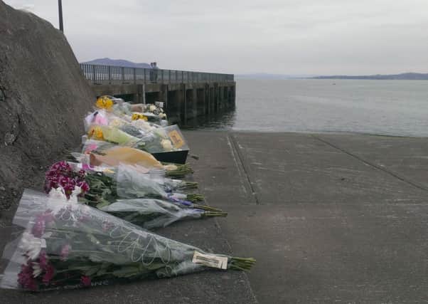 Floral tributes left at Buncrana pier following the deaths of five people trapped in a car which entered the water