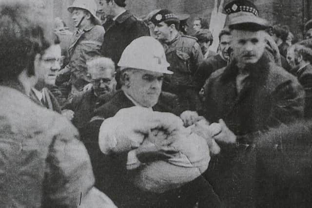 A newspaper clipping shows Jack Nichol's son Colin being removed from the rubble after a no-warning IRA bomb attack on the Shankill Road in 1971. Arthur Allison/Pacemaker.