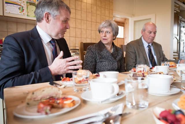 Theresa May having lunch with farmers including Barclay Bell, left, of the UFU, at Fairview Farm in Bangor, Northern Ireland on Thursday. During the visit the prime minister also answered a question from the News Letter about the possibility of a border in the Irish Sea. Photo: Stefan Rousseau/PA Wire