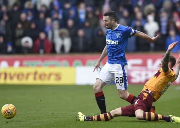 Rangers' Jamie Murphy (left) is tackled by Motherwell's Richard Tait during the Scottish Premiership match at Fir Park, Edinburgh. PRESS ASSOCIATION Photo. Picture date: Saturday March 31, 2018. See PA story SOCCER Motherwell. Photo credit should read: Ian Rutherford/PA Wire. RESTRICTIONS: EDITORIAL USE ONLY