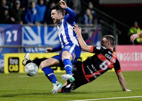 Crusaders Colin Coates brings down Coleraine's Eoin Bradley to give away a penalty