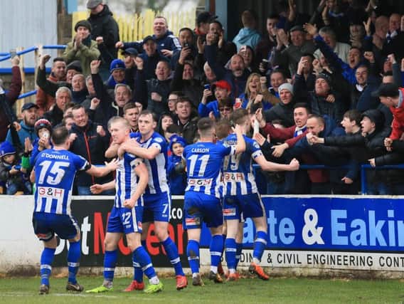 Coleraine players and fans celebrate Jamie McGonigle's late winner.