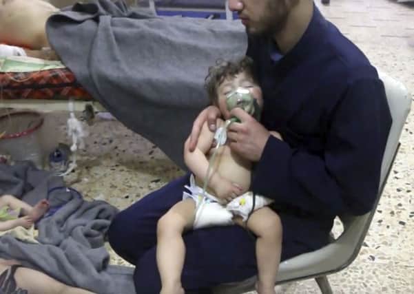This image made from video released by the Syrian Civil Defense White Helmets, which has been authenticated based on its contents and other AP reporting, shows a medical worker giving toddlers oxygen through respirators following an alleged poison gas attack in the opposition-held town of Douma, in eastern Ghouta, near Damascus, Syria, Sunday, April 8, 2018.  (Syrian Civil Defense White Helmets via AP)