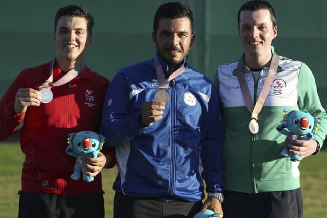 Ben Llewellin of Wales, left, silver medal, Georgios Achilleos of Crete, center, gold medal, and Gareth McAuley of Northern Ireland, right, bronze medal, during the medal ceremony for the men's Skeet final at the Belmont Shooting Centre during the 2018 Commonwealth Games in Brisbane, Australia, Monday, April 9, 2018. (AP Photo/Tertius Pickard)