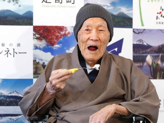 Masazou Nonaka eats a cake after receiving the certificate from Guinness World Records as the world's oldest living man at age 112 years and 259 days during a ceremony in Ashoro on Japan's northern main island of Hokkaido