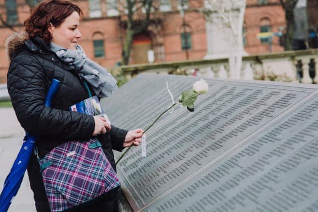 Belfast City Council handout photo of Bangor woman, Alison Kerrigan, lays a rose in memory of her great, great uncle after the Titanic Memorial Service in the grounds of Belfast City Hall