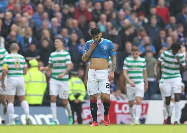 Rangers' Daniel Candeias appears dejected as Celtic players celebrate their second goal during the William Hill Scottish Cup semi final match at Hampden Park, Glasgow. Photo: Andrew Milligan/PA Wire.