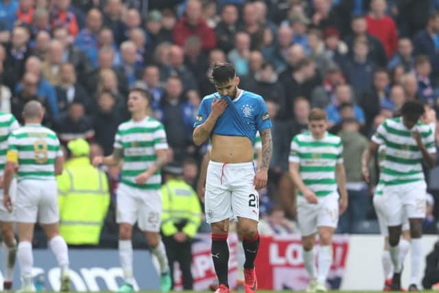 Rangers' Daniel Candeias appears dejected as Celtic players celebrate their second goal during the William Hill Scottish Cup semi final match at Hampden Park, Glasgow. Photo: Andrew Milligan/PA Wire.