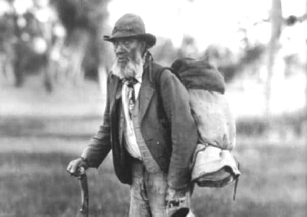 A typical 'jolly' swagman, c 1901, with billy can and swag on his back