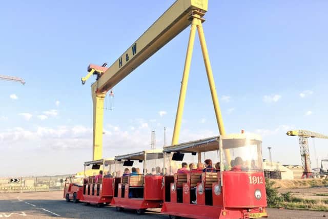 The Wee Tram tour pulls up alongside the famous cranes in Belfast's Titanic Quarter