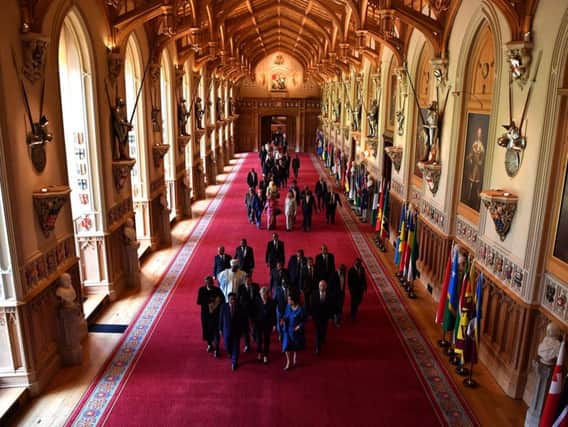 (Front left to right) Seychelles' President Danny Faure, Prime Minister Theresa May and Commonwealth Secretary General Patricia Scotland lead other leaders down St George's hall at Windsor castle during the Commonwealth Heads of Government Meetin