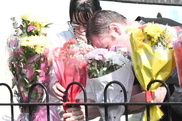 Mourners leave flowers at the scene