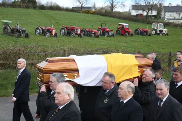 The funeral cortege makes it way to Saint Patrick's Church in Oram, County Monaghan, for the funeral of country music star Big Tom McBride, pass a line of vintage tractors, some of which belonged to the singer.