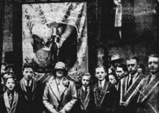 Sister Margaret Drennan unfurls the new banner of King Williams Young Defenders Junior LOL in 1928