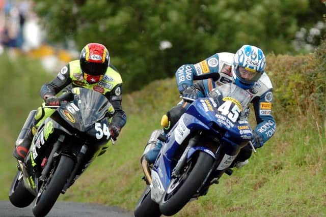 Lusk man Martin Finnegan in typical all-action style on the Danfay Yamaha at the Mid Antrim 150 in 2004. Finnegan has just passed Donegal man Ray Porter at Fenton's Jump. Picture: Stephen Davison/Pacemaker Press.